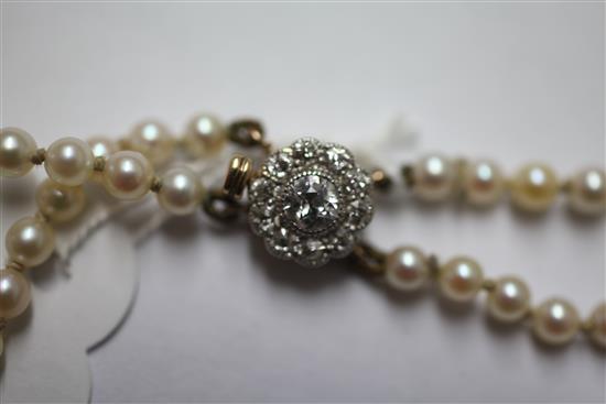 An early 20th century double strand graduated cultured pearl necklace with circular diamond cluster clasp, 16.5in.